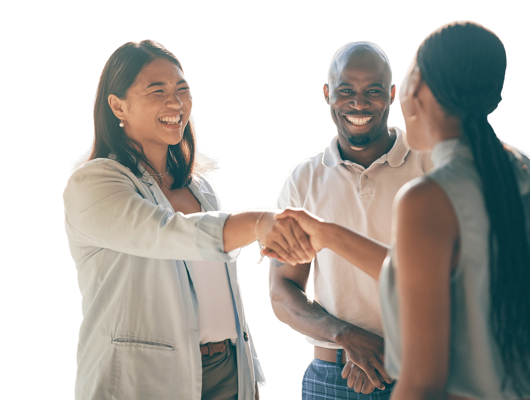 Three people engaging in a handshake and smiling, suggesting a friendly interaction or meeting.